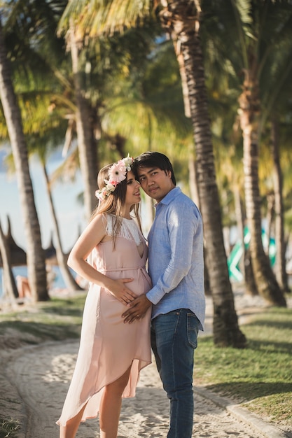 Beautiful pregnant girl and man on the beach