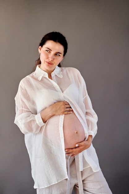 Beautiful pregnant girl in a shirt with a bare stomach