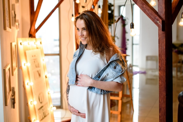 Beautiful pregnant girl in white dress.