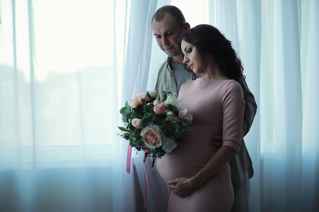 Beautiful pregnant girl with a big belly. Young married pregnant couple. Husband with a pregnant wife. A couple awaiting the birth of a baby.