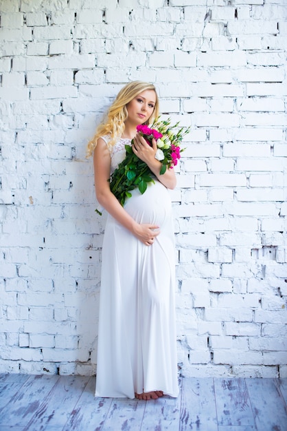 A beautiful pregnant lady with a bouquet of flowers waiting for the baby Pregnancy