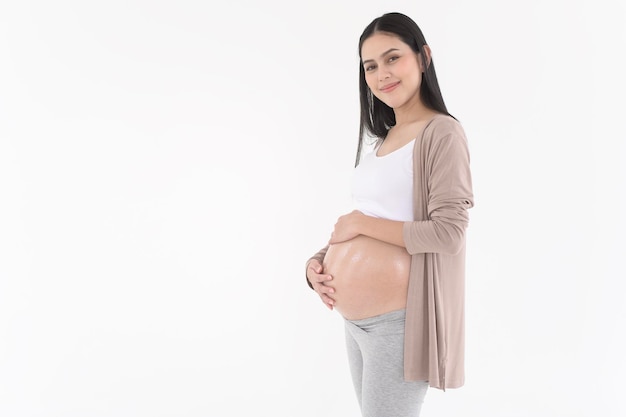 Beautiful pregnant woman applying moisturizing stretch mark cream on belly