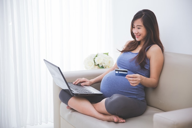 Красивая беременная женщина покупает вещи онлайн