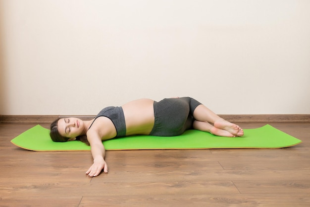 Beautiful pregnant woman doing yoga at home pregnancy yoga and\
fitness concept at coronavirus time