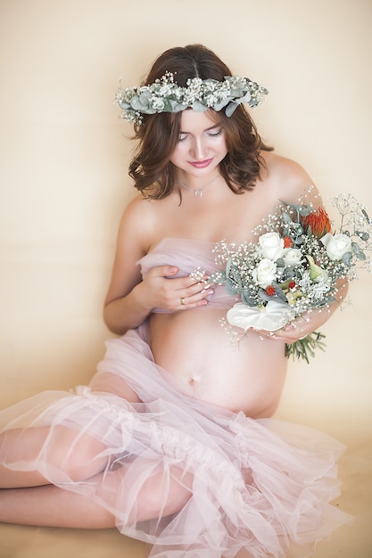 Beautiful pregnant woman on neutral scene. Expectant closeup picture. 