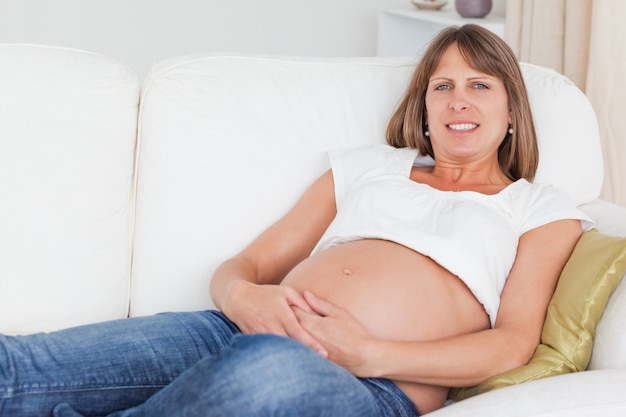 Beautiful pregnant woman posing while lying