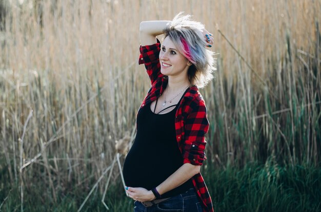 Beautiful pregnant woman relaxing outside in the nature