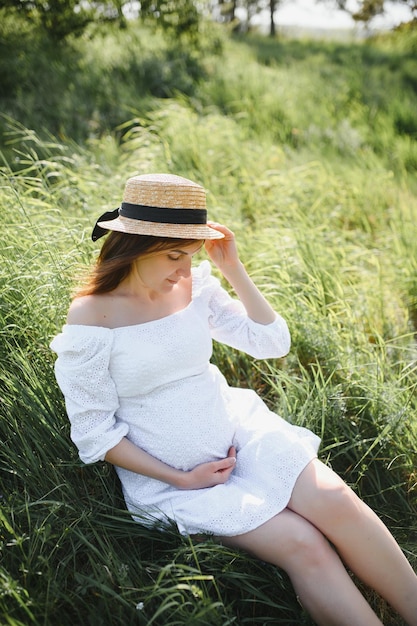 美しい妊娠中の女性は、公園の外でリラックス
