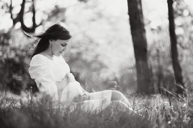 Beautiful pregnant woman relaxing outside in the park