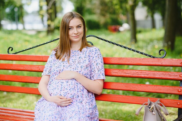 Beautiful pregnant woman relaxing in the park