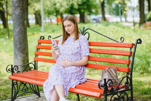 Beautiful pregnant woman relaxing in the park