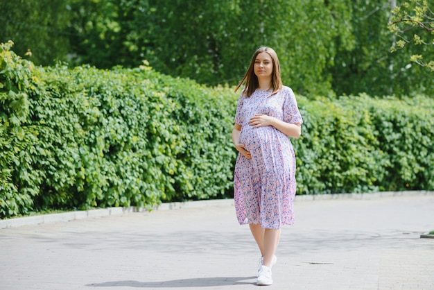 Beautiful pregnant woman relaxing in the park