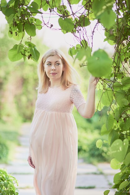 beautiful pregnant woman smell flowering tree