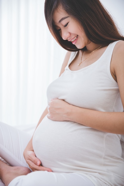 Beautiful pregnant woman smiling in to her belly