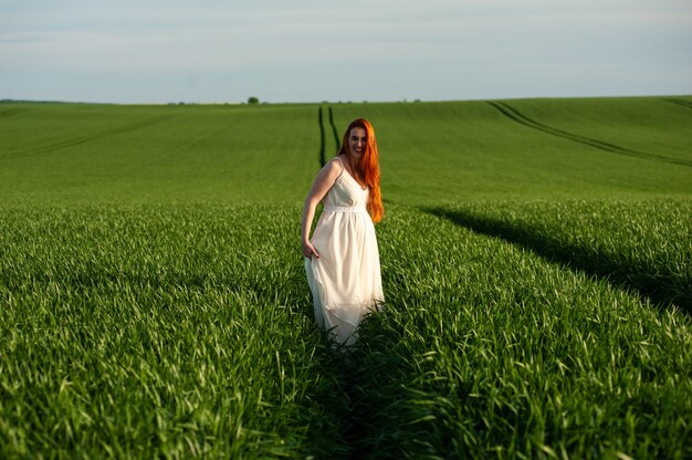Фото Красивая беременная женщина летний портрет прогулки на зеленом поле