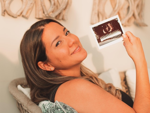 Beautiful pregnant woman watching the echo of her baby