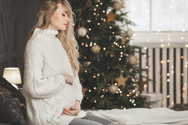 Bella donna incinta con decorazioni natalizie
