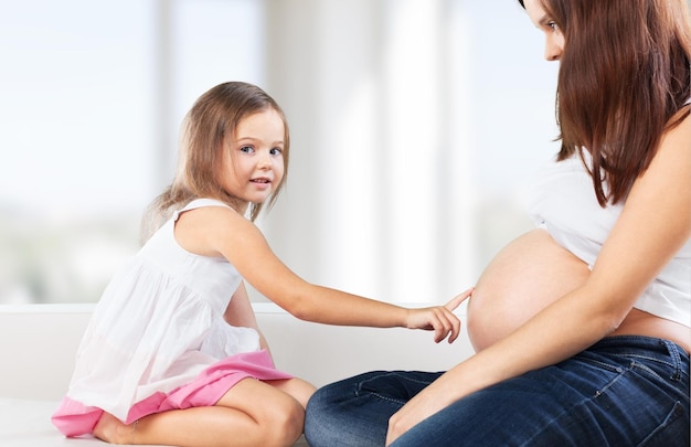 Beautiful pregnant woman with her daughter.