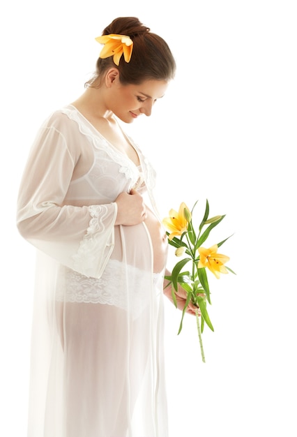 흰색 위에 노란색 릴리와 함께 아름 다운 임신 한 여자