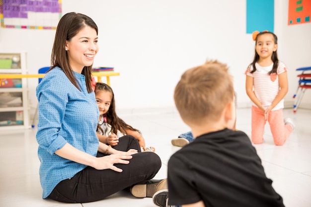教室で生徒たちと楽しんでいる美しい幼稚園の先生