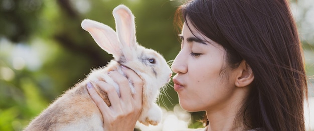 写真 ペットと動物のケアのコンセプトでかわいいウサギを持つアジアの若い女性人の美しいかなりの肖像画