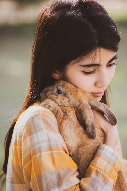 Bellissimo bel ritratto di giovane donna asiatica persona con coniglio carino in pet e concetto di cura degli animali felice femmina che tiene coniglietto al campo all'aperto della natura con il concetto di pasqua di amicizia