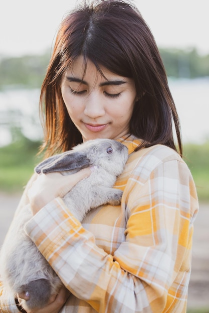 Beautiful pretty portrait of young asian woman person with cute
rabbit in pet and animal care concept happy female holding bunny at
nature outdoor field with friendship easter concept