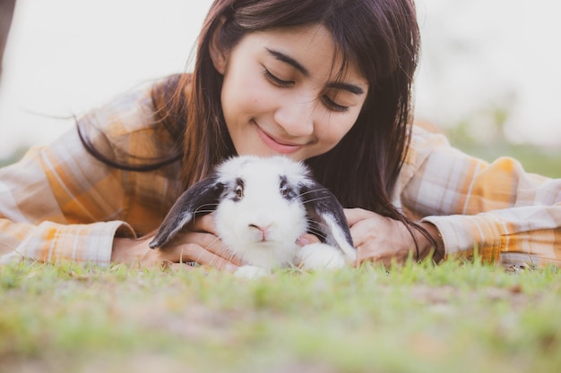 Beautiful pretty portrait of young asian woman person with cute
rabbit in pet and animal care concept happy female holding bunny at
nature outdoor field with friendship easter concept