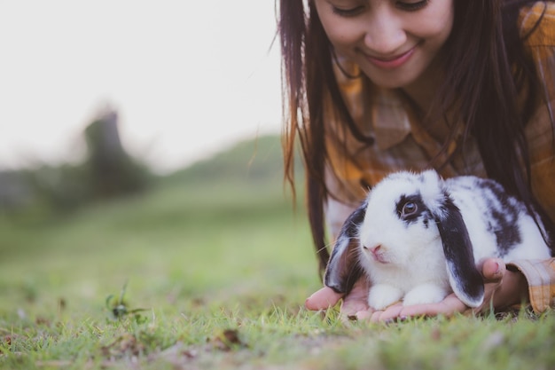 Beautiful pretty portrait of young asian woman person with cute
rabbit in pet and animal care concept happy female holding bunny at
nature outdoor field with friendship easter concept