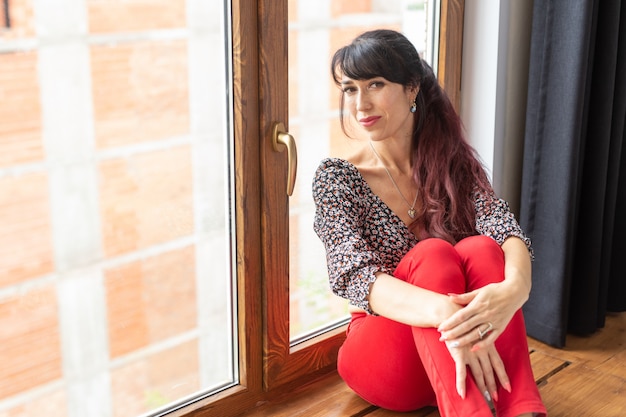 Beautiful pretty slim woman sitting by the window.