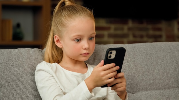 아름 다운 예쁜 작은 여자 학생 백인 아이 아이 딸 블로거 집에서 소파에 앉아 사용