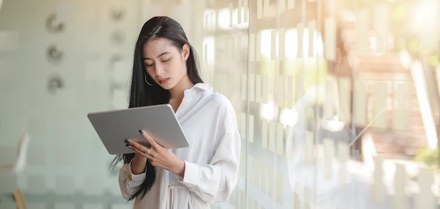 Beautiful professional designer working on her project with tablet