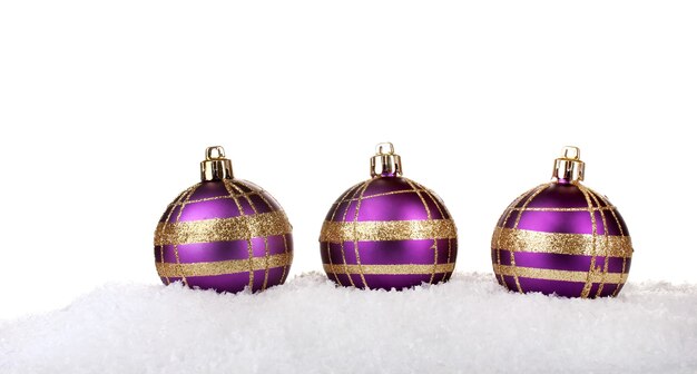 Beautiful purple Christmas balls in snow isolated on white