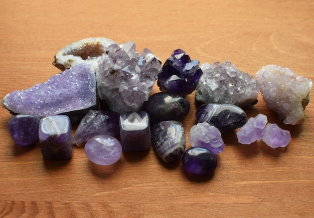 Beautiful purple crystals and amethyst druze lie on a wooden background Magic amulets