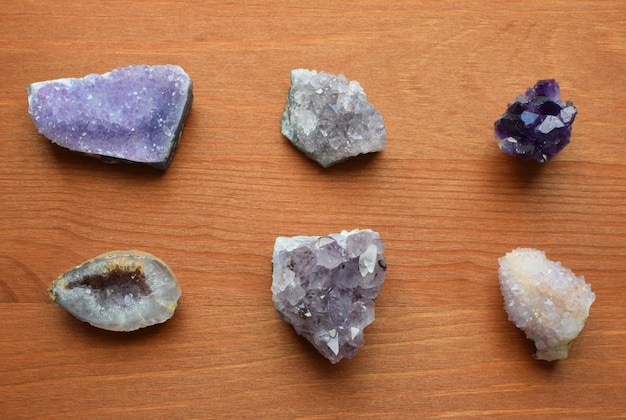 Photo beautiful purple crystals and amethyst druze lie on a wooden background