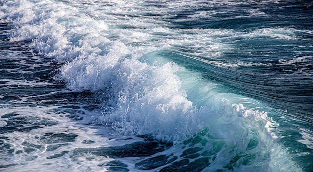 Beautiful raging seas with sea foam and waves. Background of turquoise waves.