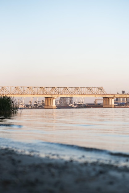 Красивый железнодорожный мост на фоне залива на закате