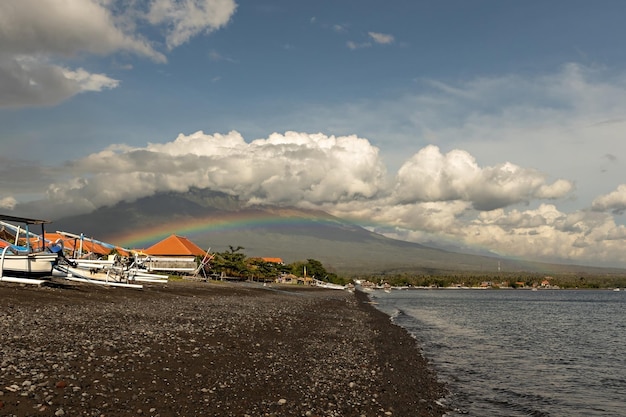 Beautiful rainbow over Agung volcano on sunny day Amed beach Bali Indonesia