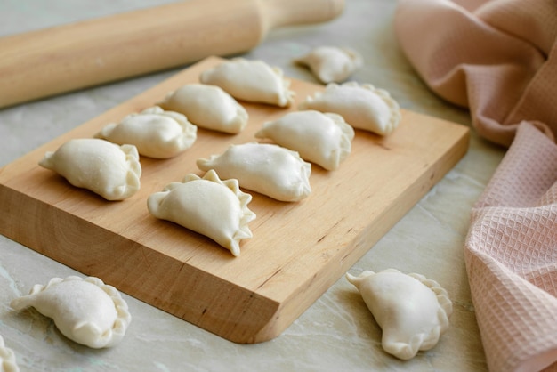 Beautiful raw stuffed dumplings on a wooden cutting board Delicious fast food