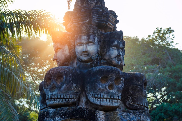 Wat Xieng Khuan Buddha Park에서 불교와 힌두교 신화의 일몰 조각상이 아름답게 빛납니다. 비엔티안, 라오스