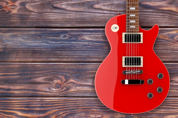 Photo beautiful red electric guitar in retro style on a wooden table. 3d rendering