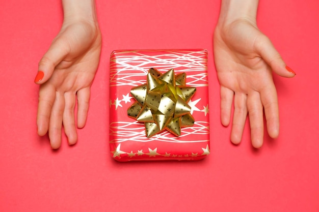 여자의 손에 활이 있는 아름다운 빨간 선물 상자