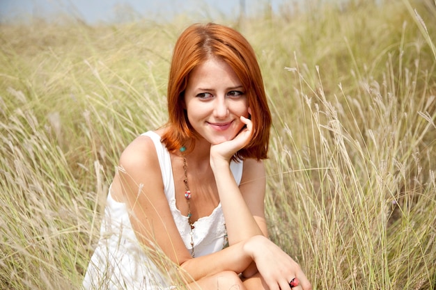 Beautiful red-haired girl at grass.