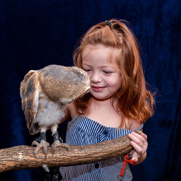 彼女のペットのフクロウと美しい赤い髪の少女