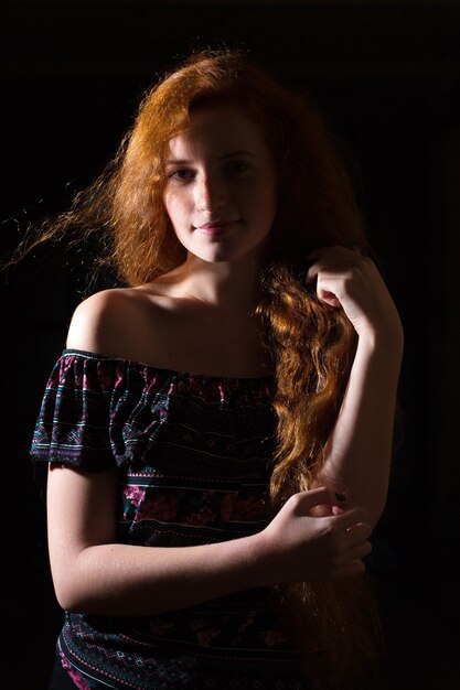 Beautiful red haired woman with lush hair with naked shoulders