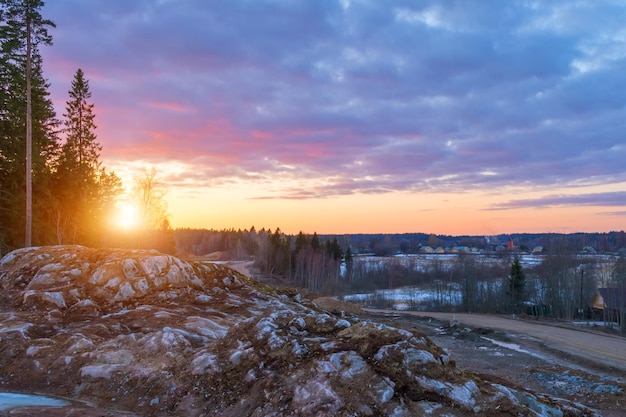 Bellissimo tramonto rosso arancione nel cielo sopra le scogliere delle montagne e alti pini pittoresche nuvole illuminate dal sole