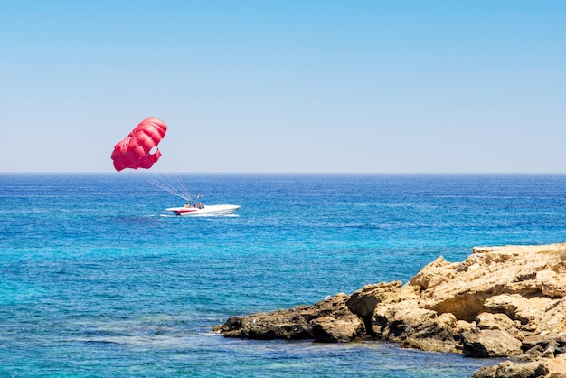 Beautiful red parachute at the sea of nature of Cyprus. Parasailing.