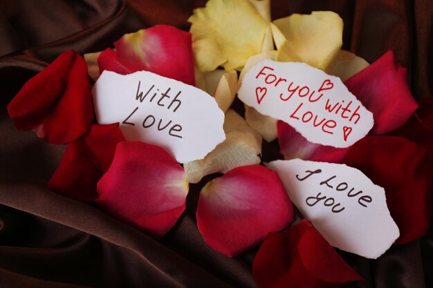 Photo beautiful red rose petals and greeting cards, close up