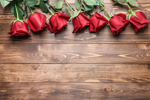 Beautiful red roses on wooden background