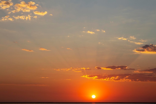 地平線上の美しい赤い夕日と明るい太陽